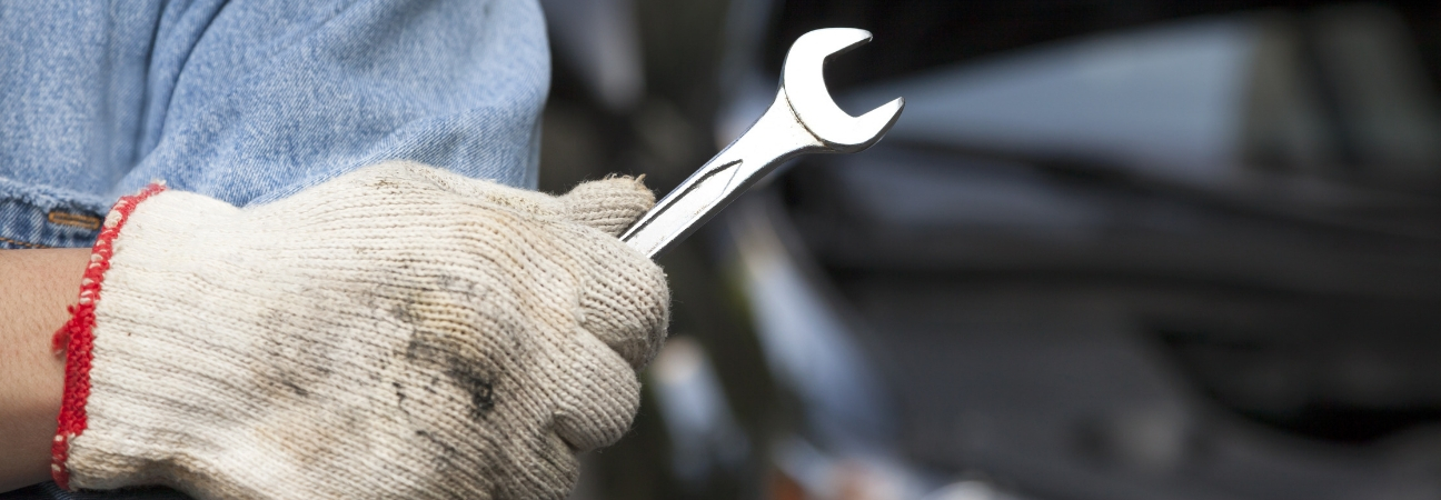 A close-up of someone holding a wrench in a blog post about the collision repair process