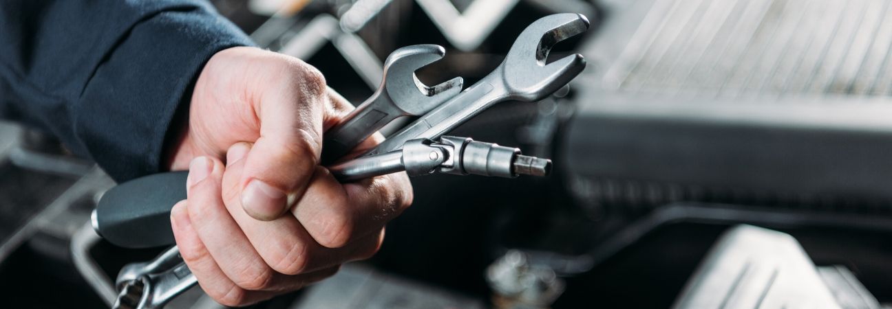 a car mechanic with wrenches in his hand